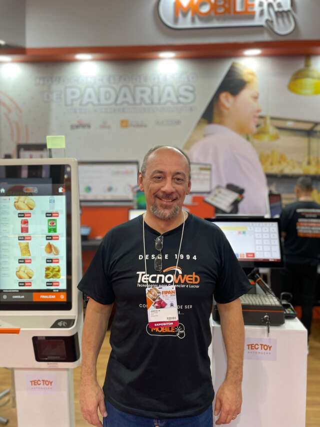 Marcio Goulart Jr em frente às soluções Sammi Touch e Sammi Totem da Tecnoweb nos equipamentos D2s Combo e K2 da Tectoy na FIPAN 2024